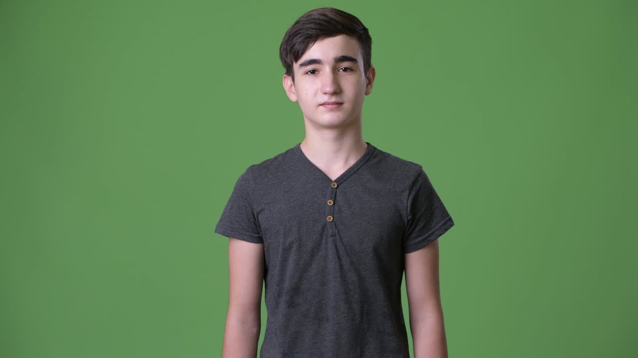 joven y guapo adolescente iraní contra un fondo verde