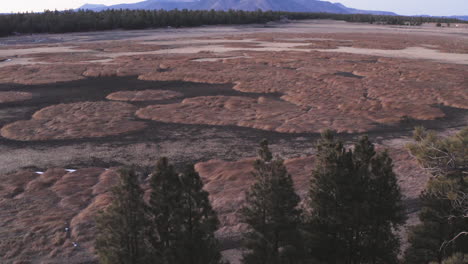 aerial flyover dry lake bed and mountain in background during climate change