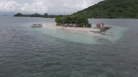 Man-swings-on-beach-swing-on-small-sandy-islet-as-aerial-withdraws