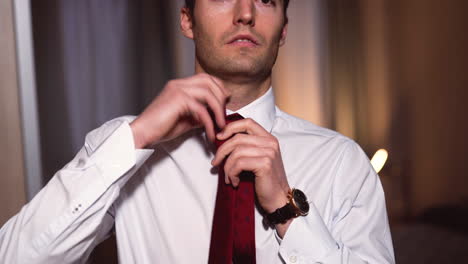 Successful-business-man-in-a-white-shirt-ties-a-red-tie-around-his-neck