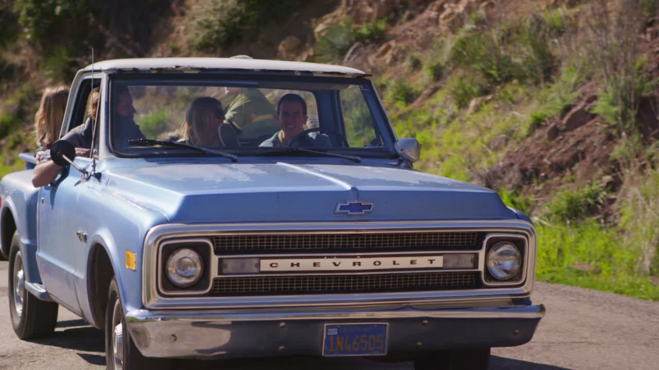 파란 픽업트럭을 타고 시골길을 달리는 친구들 1