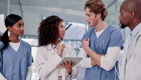 medical team discussing patient care using a tablet