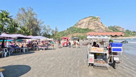 vendors and visitors at a sunny beach market