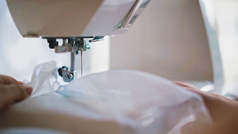 hands of young woman sews