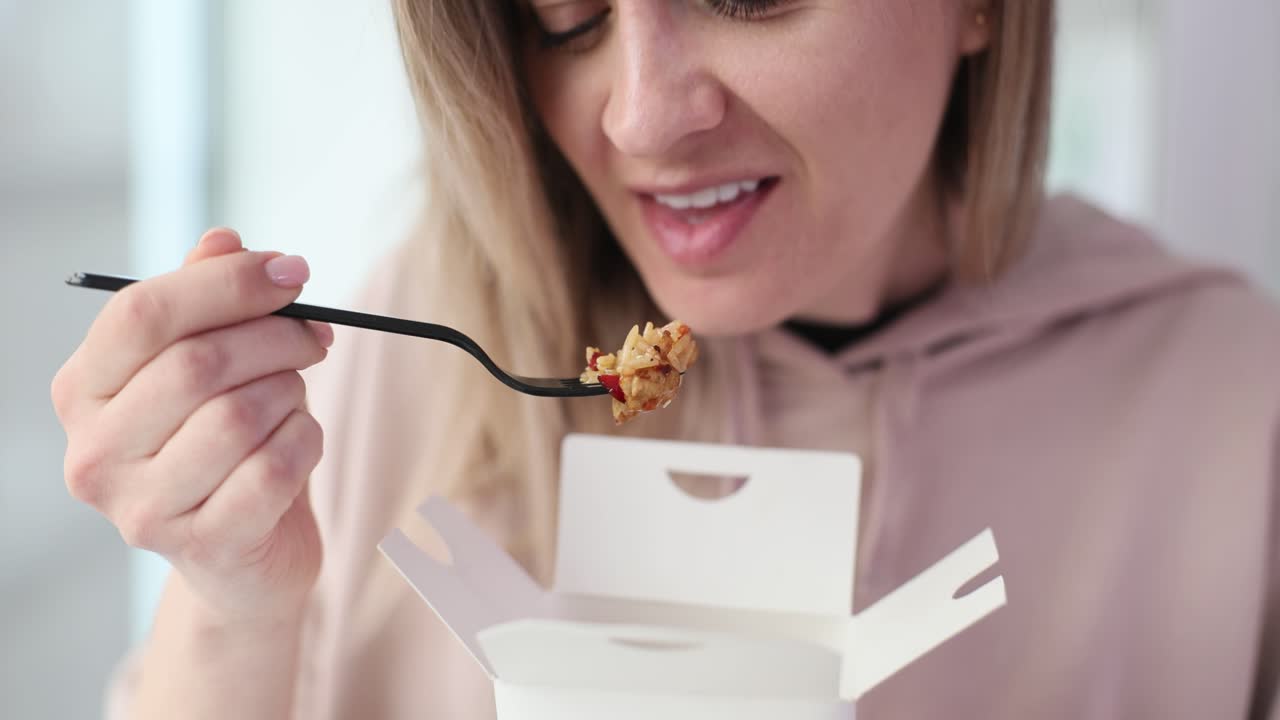 Woman eating takeout Asian food