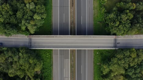 car passing the bridge above the highway