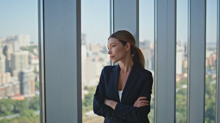Confident businesswoman standing panoramic window. Successful executive thinking