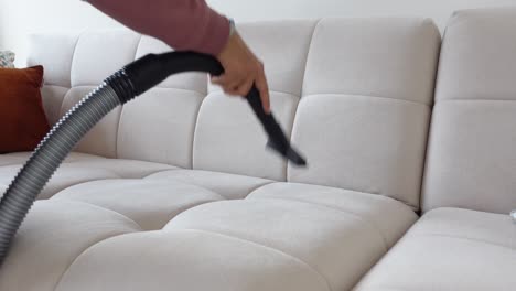 woman vacuuming a white couch