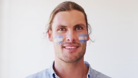 image of happy caucasian man with flag of argentina looking at camera