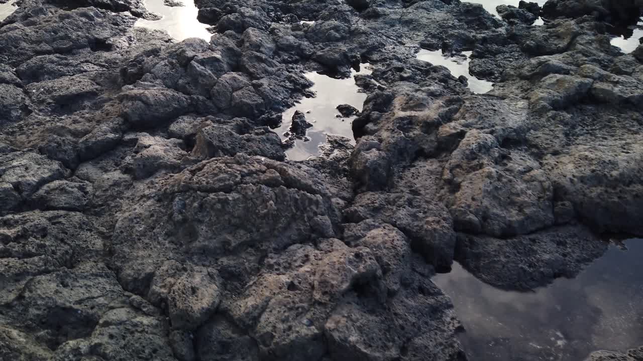 Primo piano di lava solidificata con pozzanghere di acqua di mare