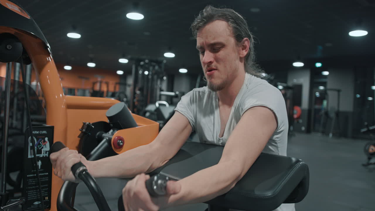 실내 체육관 에서 무거운 무게 를 들여 팔 을 운동 하는 사람
