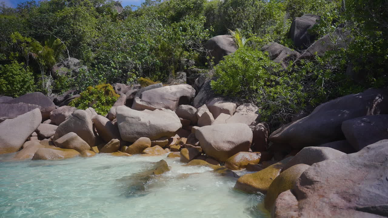 Una piccola spiaggia rocciosa su un'isola deserta nelle bellissime e tropicali Seychelles