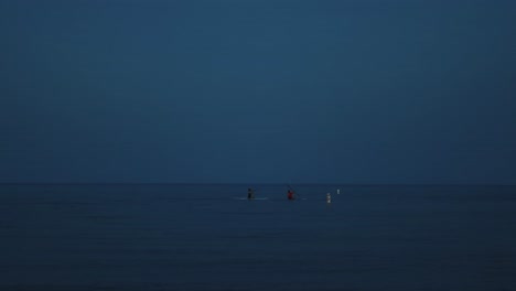 Zwei-Paddle-Boarder-Stehen-Vor-Der-Sonne-Im-Ruhigen,-Tiefblauen-Meer