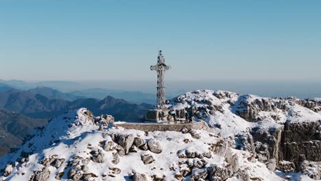 climbers on summit cross of resegone mountain in northern italy