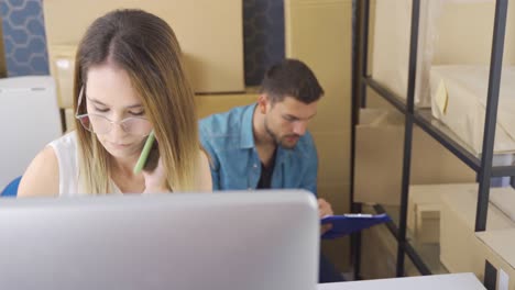 Female-Marketer-Using-Computer-While-Checking-Orders-In-E-Commerce-Store.