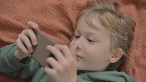 Porträt-Eines-Kleinen-Jungen-Mit-Einem-Smartphone,-Das-Ein-Video-Ansieht