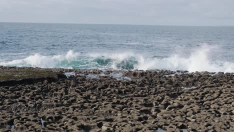 Huge-waves-crashing-into-rocky-shoreline-in-slow-motion