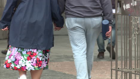 older couple walking hand-in-hand on city street