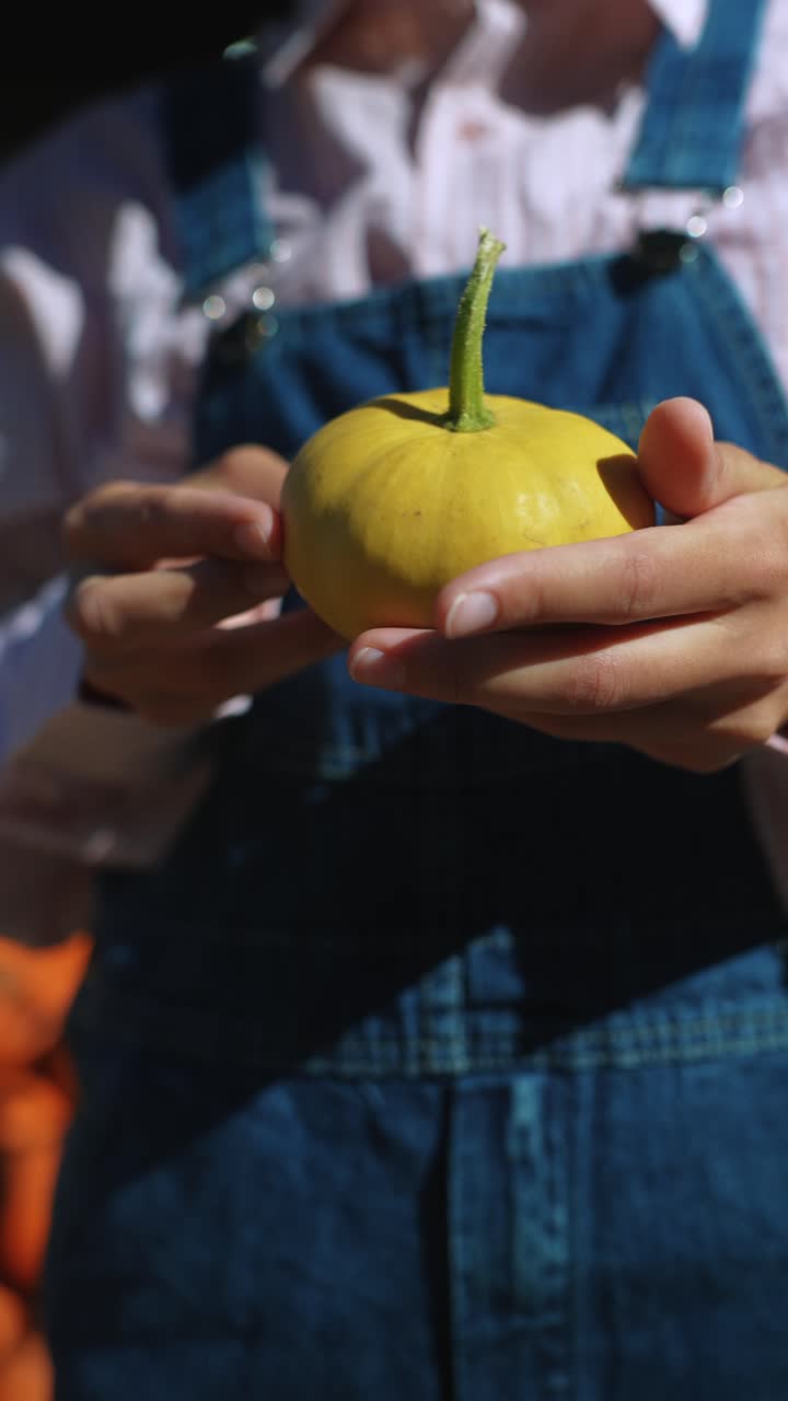 작은 노란색 호박을 들고 있는 아이