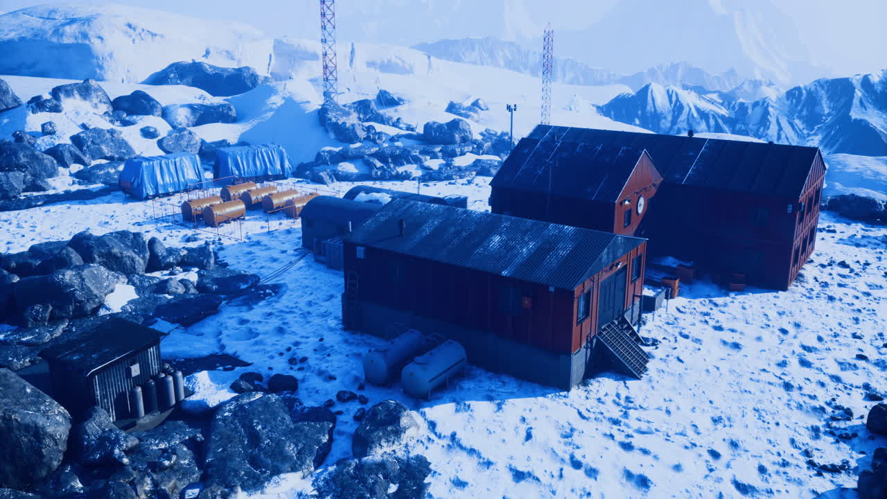 A remote research station stands surrounded by snow covered mountains