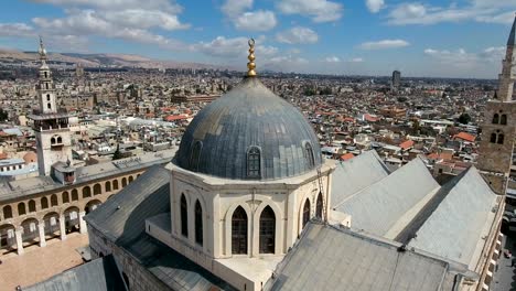 beautiful view over the umayyad mosque in syria. drone is flying over the mosque with the city of damascus in the background.