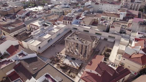 Aerial-view-circling-above-remains-of-the-temple-of-Diana-in-the-centre-of-historic-Merida,-Spain