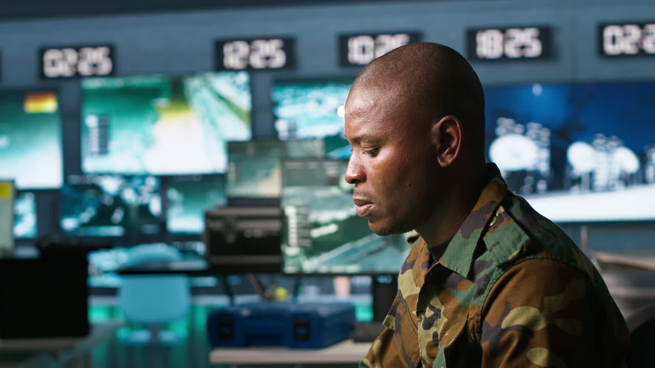 Portrait of military agent working in control room, analyzing aerial data