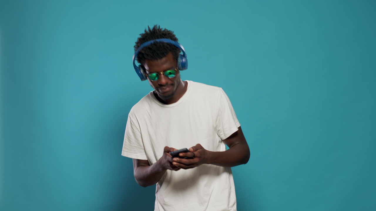 Person jumping and listening to music while using smartphone