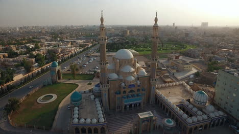 shot from left to right of a large mosque with domes and beacons