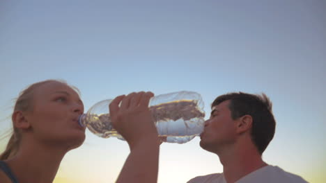 couple drinking water after exercises