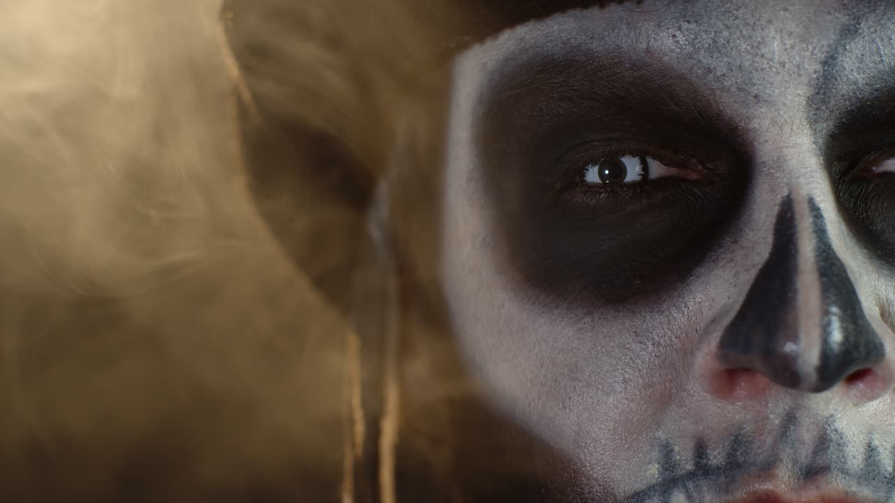 fotografía macro de cerca de la cara de un hombre espeluznante y aterrador con maquillaje de esqueleto abriendo los ojos con pupila blanca