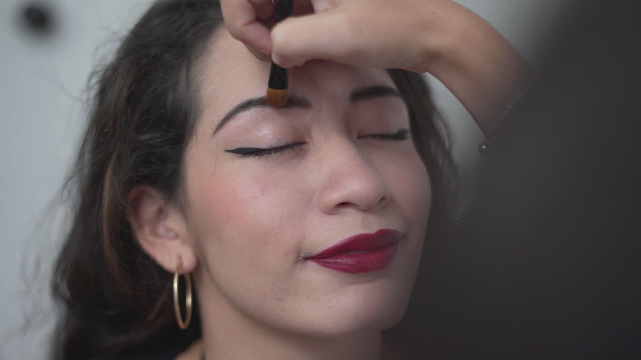 mujer haciendo una aplicación de maquillaje
