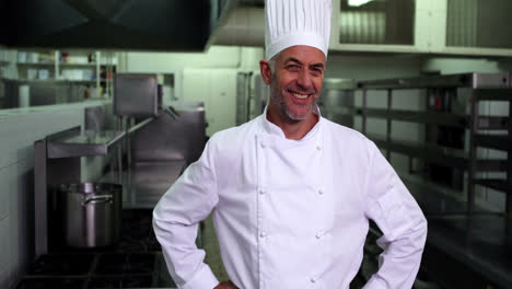 jefe de cocina sonriendo a la cámara con las manos en las caderas
