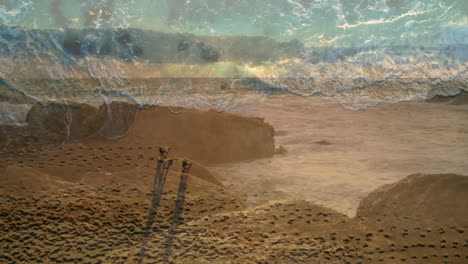waves crashing on sandy beach, people walking along shoreline with footprints