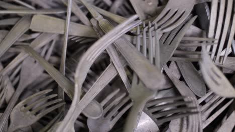 Pile-of-aged,-tarnished-forks,-mixed-design-old-collectible-flatware