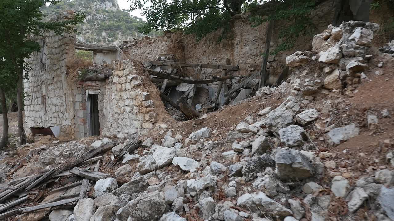 Street full of rubble and ruins of stone houses in the abandoned village of Otiñar, Jaén