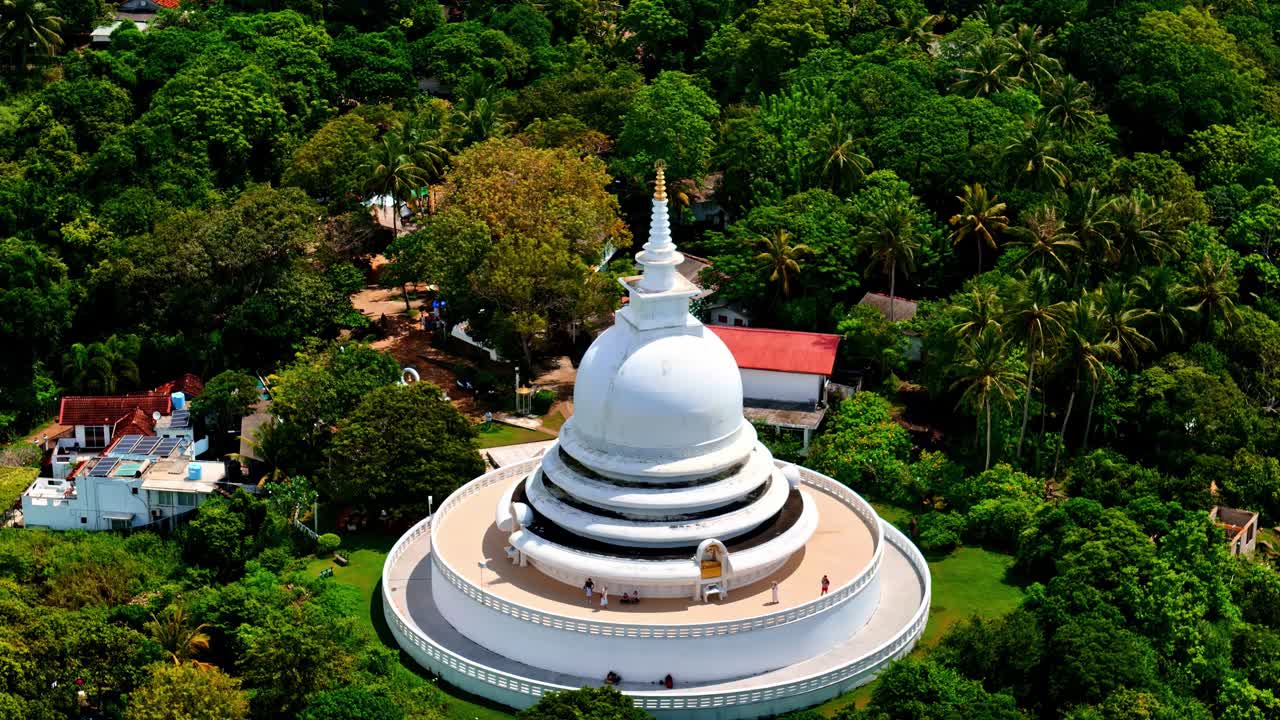 Veduta aerea della Pagoda della Pace Giapponese a Rumassala, uno stupa bianco su una lussureggiante collina verde circondato da foresta tropicale