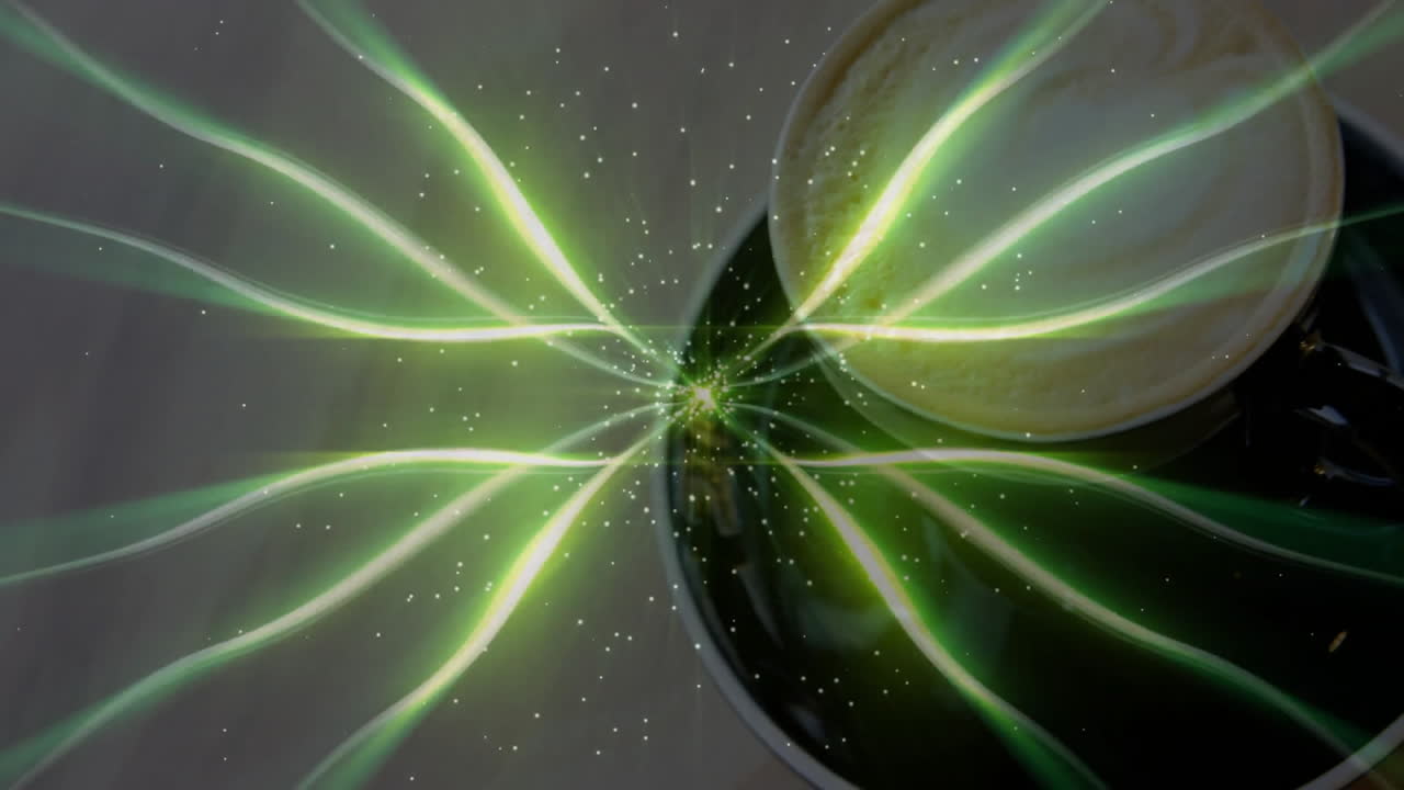 Dark ceramic coffee cup being surrounded by green glowing light trails dancing across grey tabletop