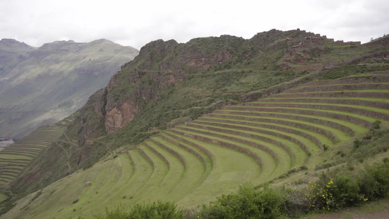 antiguas plataformas incas con montañas en el fondo en el parque arqueológico de pisac en pisac, región de cuzco, perú