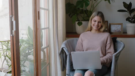 Mujer-Joven-Feliz-Usando-Una-Computadora-Portátil-Trabajando-Desde-Casa-Navegando-En-Línea-Viendo-Entretenimiento-Disfrutando-Relajándose-El-Fin-De-Semana