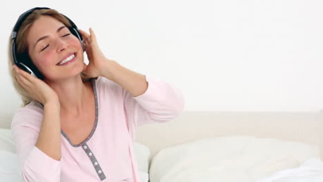 blonde enjoying music in bedroom