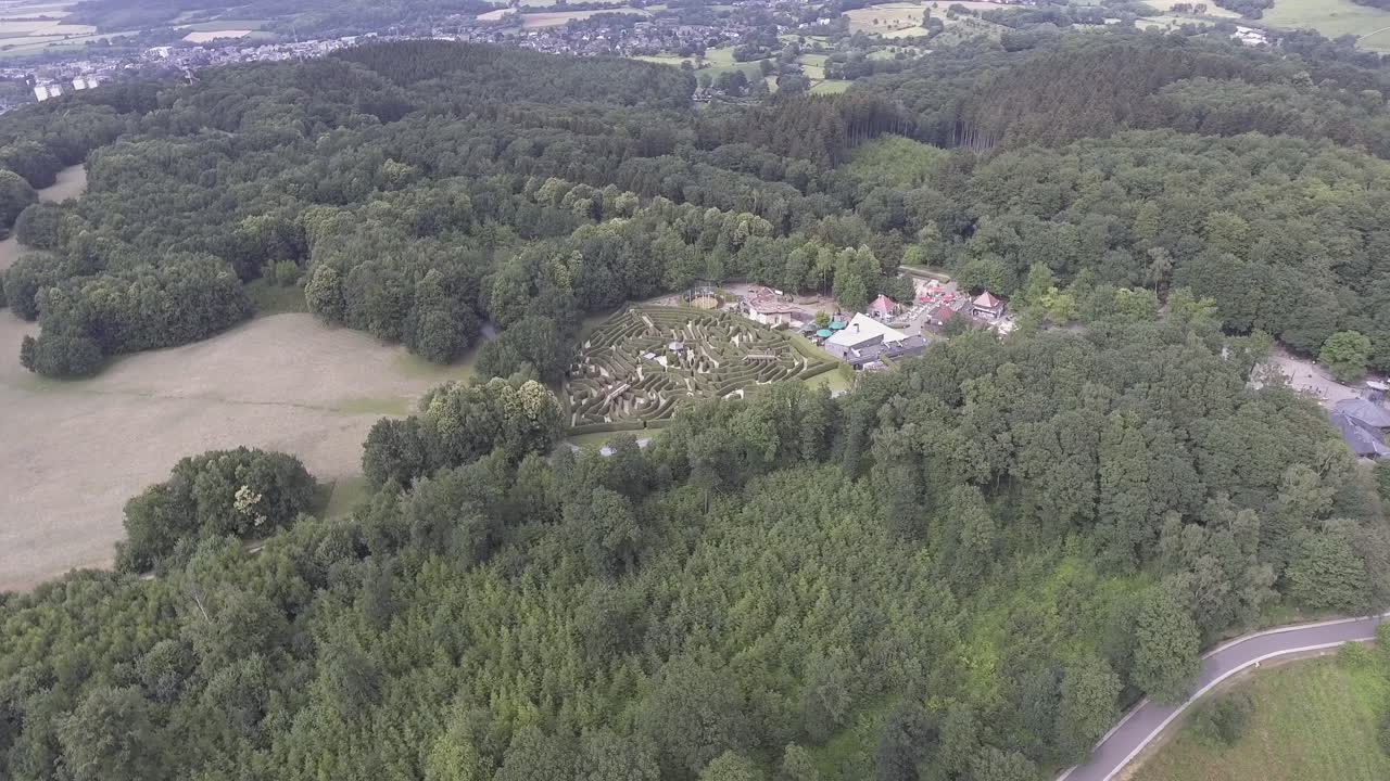 A drone shot flying high and panning left, whilst showing a maze in the middle of the frame, in the Netherlands