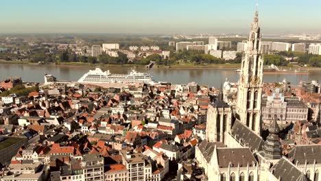 antwerp cathedral view over cruise ship anchored on scheldt river, belgium - aerial wide panoramic shot