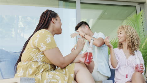 Young-Asian-man-and-biracial-women-enjoy-a-lively-conversation-at-home