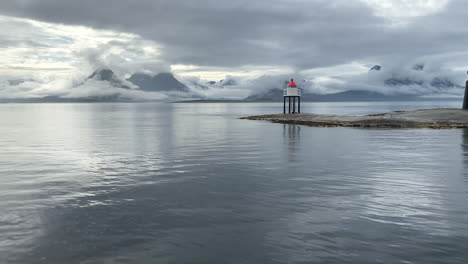 Nubes-Que-Rodean-Las-Montañas-De-La-Costa-De-Helgeland-Durante-La-Lluvia-Con-Un-Faro-Y-Una-Pequeña-Isla