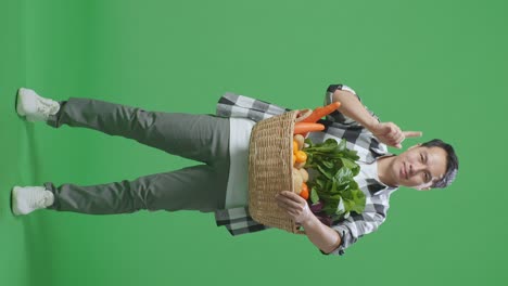 hombre sosteniendo una canasta de verduras