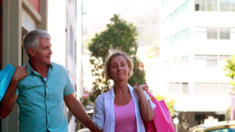 pareja feliz en un día de compras caminando y tomándose de la mano