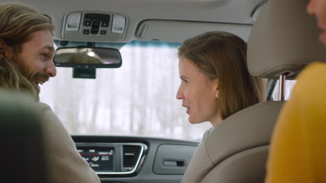 happy friends sitting in a car talking and laughing together