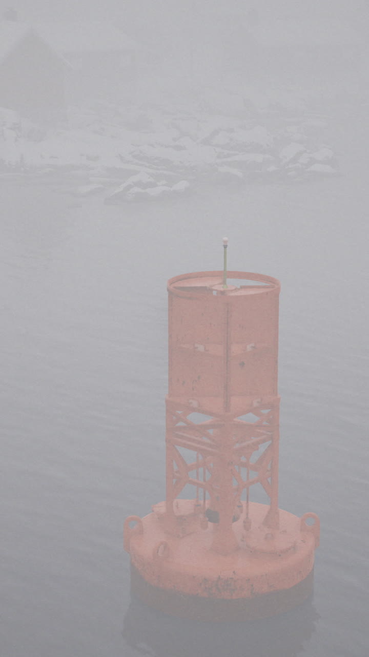 Misty ocean view with a buoy standing in the fog during early morning hours
