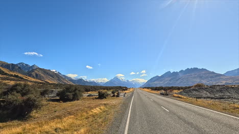 scenic road leading to majestic mountains under a sunny sky